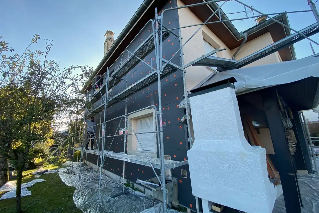Façade de maison en cours de travaux, sous échafaudage.